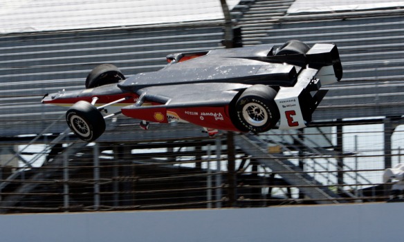 The car driven by Helio Castroneves, of Brazil, is airborne after hitting the wall in the first turn during practice for the Indianapolis 500 auto race at Indianapolis Motor Speedway in Indianapolis, Wednesday, May 13, 2015.  (AP Photo/Joe Watts) ORG XMIT: NAA107